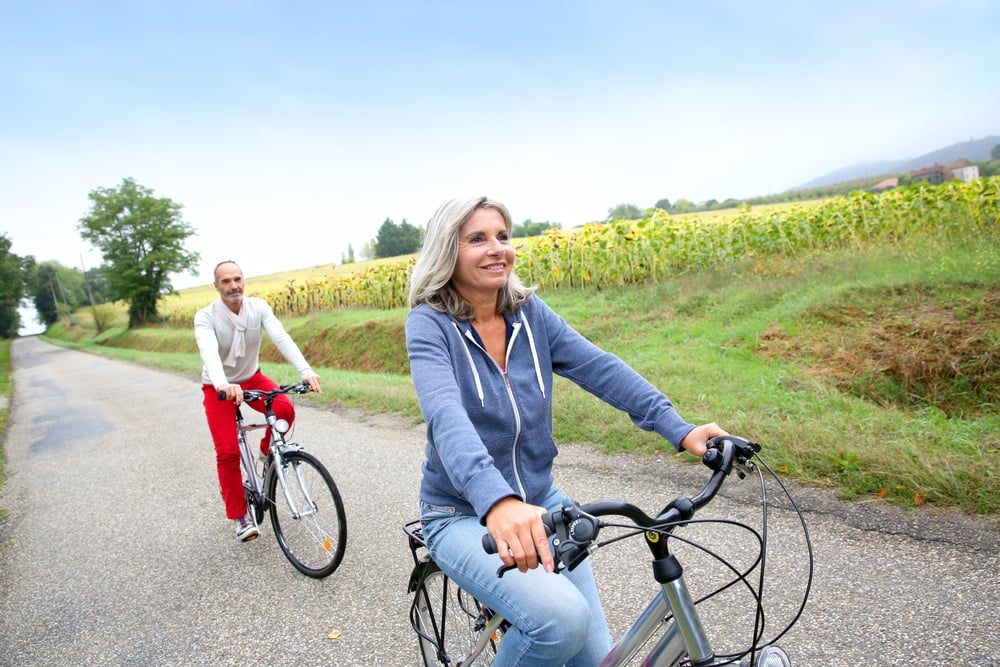 Senior couple riding bicycle in countryside Senior couple riding bicycle in countryside